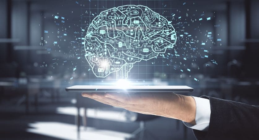 Tablet de mão segura com interface cerebral de circuito brilhante em fundo escuro de escritório.Comportamento do consumidor e neuromarketing